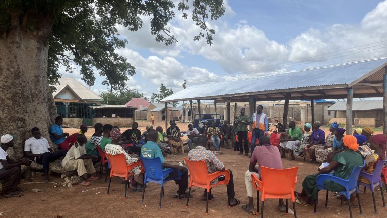 Community meeting under a shade tree facilitated by RACED Ghana