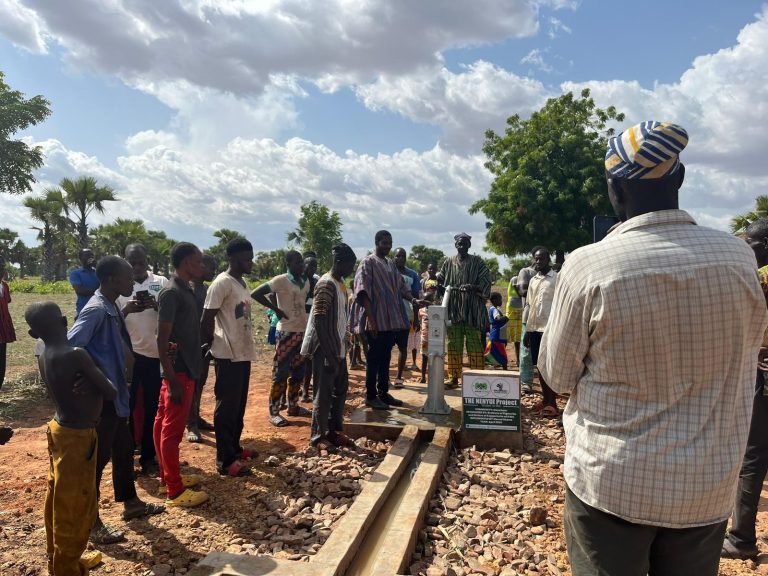 Joint monitoring team inspecting a community borehole
