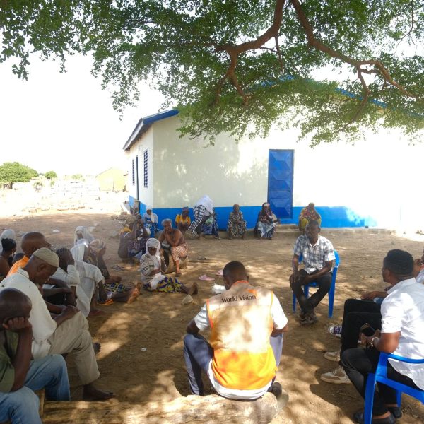 Community volunteers meeting near a health facility