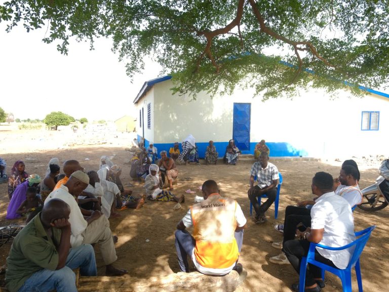 Community volunteers meeting near a health facility