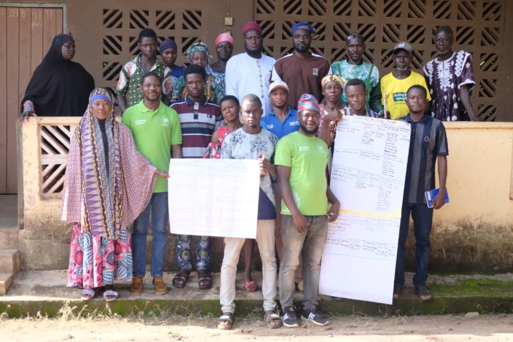 Community advocates and RACED Ghana staff holding workshop planning charts